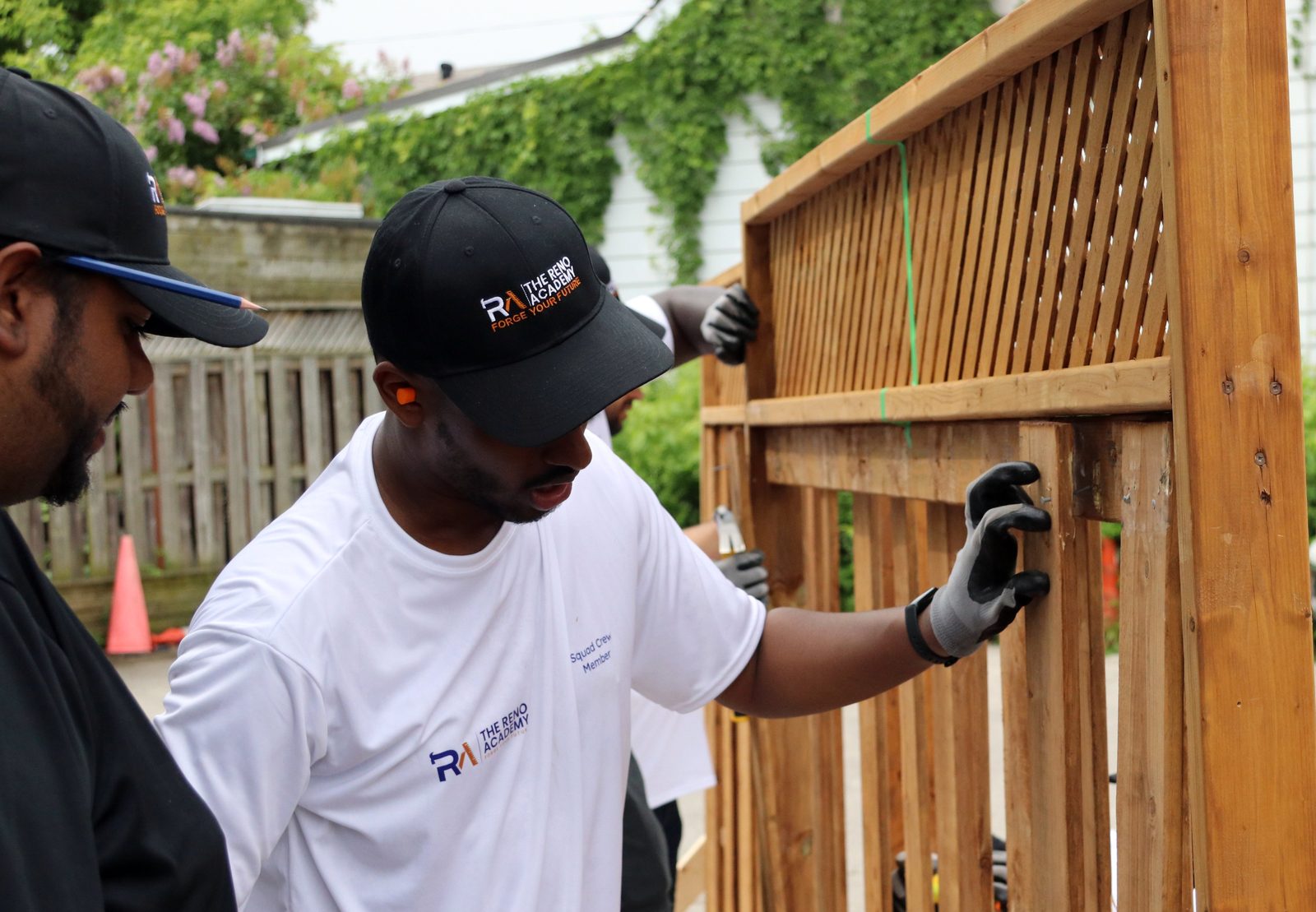 Site Squad Bootcamp LE student inspecting a cedar fence panel with classmates in Toronto
