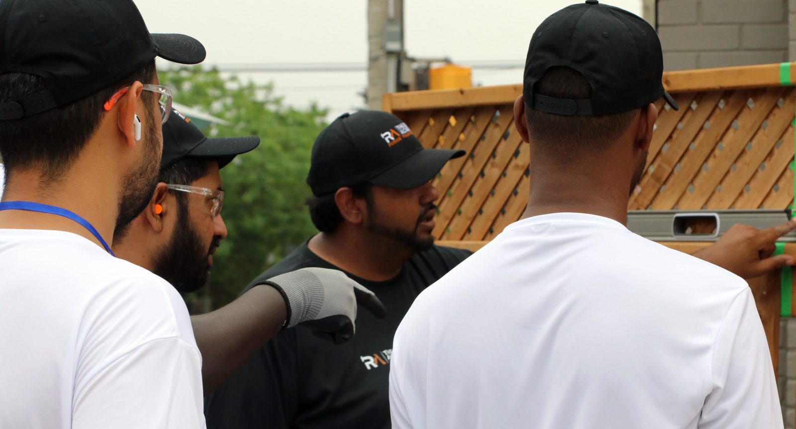 Site Squad Bootcamp LE participants and coach at an outdoor fence-building station during trades training in Toronto