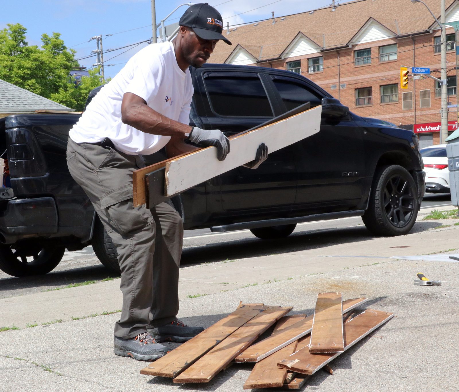 Reno Academy coach handling demolition lumber outside on a Toronto training site