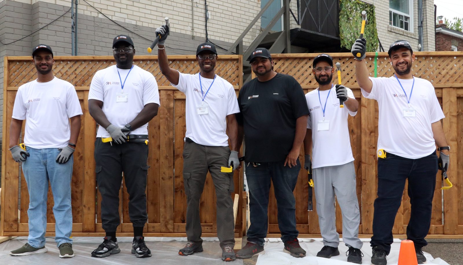 Site Squad Bootcamp LE graduates in front of the cedar fence they built during trades training in Toronto