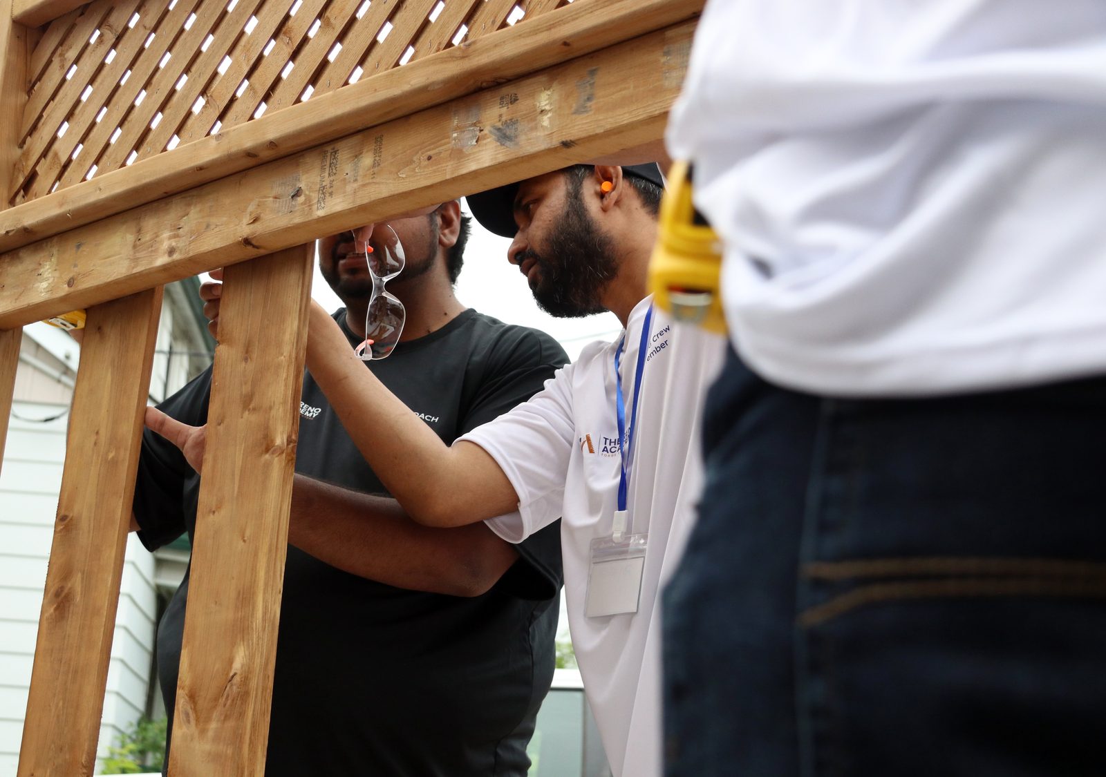 Small group of Reno Academy trainees building a fence frame together during property-maintenance training in the GTA